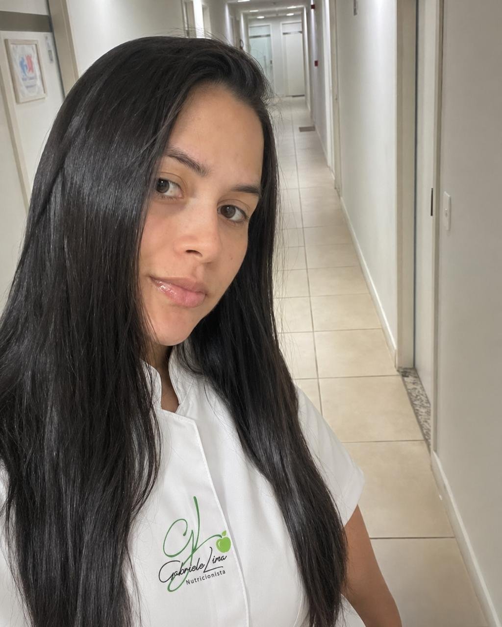 Gabriele Lima com uniforme profissional em ambiente clínico.